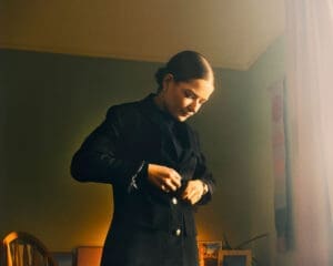 http://Woman%20putting%20on%20jacket%20in%20bedroom,%20green%20room,%20light,%20changing