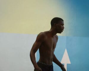 http://An%20athletic,%20shirtless%20Black%20basketball%20player%20stands%20in%20profile%20against%20the%20iconic%20color-blocked%20wall%20of%20the%20Pigalle%20court%20in%20Paris.%20The%20background%20is%20composed%20of%20yellow%20and%20blue%20sections,%20with%20a%20white%20arrow%20pointing%20upwards.%20ben%20stockley,%20ben%20stockley%20photography,%20ben%20stockley%20filmmaker,%20stockley,%20ben%20stockley%20london,%20photographer,%20photography,%20editorial,%20art,%20commercial,%20advertising,%20awards,%20gallery,%20visual%20artist,%20short%20film,%20cinematic,%20documentary,%20basketball,%20Paris,%20Pigalle,%20streetball,%20community,%20friendship,%20youth%20culture,%20sports%20documentary,%20energetic,%20vibrant,%20authentic,%20brotherhood,%20urban,%20directorial%20work,%20slow%20motion,%20sun%20flare,%20storytelling,%20branded%20content