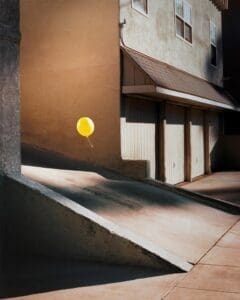 http://Bright%20yellow%20balloon%20floating%20in%20a%20sunlit%20urban%20alleyway%20against%20a%20beige%20stucco%20wall,%20with%20a%20concrete%20ramp%20in%20the%20foreground.