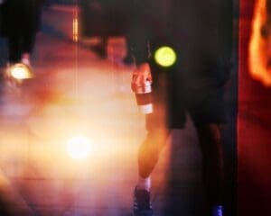 http://Blurry%20image%20of%20a%20person%20walking%20away%20at%20night%20holding%20a%20coffee%20cup,%20with%20prominent%20bokeh%20lights